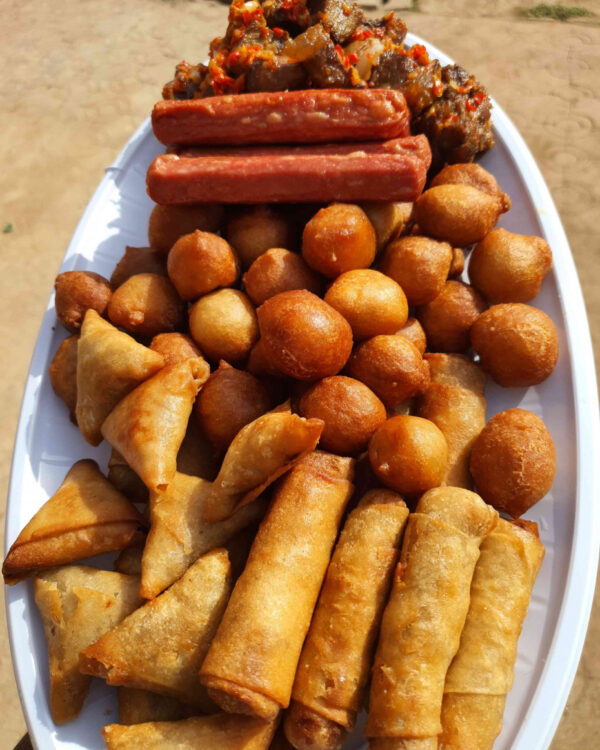 Big tray of puff puff, samosa, spring rolls and gizzard